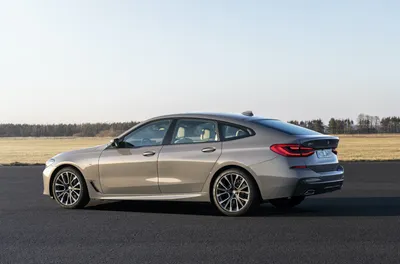 BMW M550i Gran Turismo 2023: фото на фоне городской панорамы