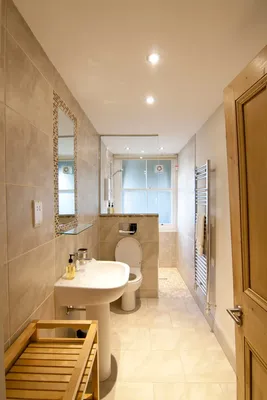 Фотография узкой ванной комнаты с душевой кабиной с различными аксессуарами
