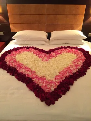 Кровать с лепестками роз: фотография, передающая теплоту и нежность