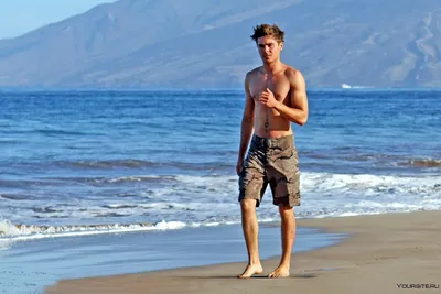 Фотография мужчины на пляже с красивыми ракушками