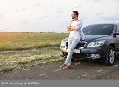 Фото мужчины, стоящего рядом с автомобилем