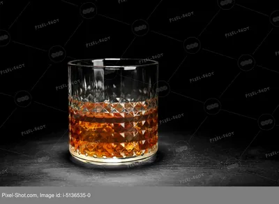 Фото роскошного стакана виски с прекрасной световой игрой