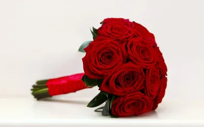 Фото свадебного букета из красных роз среди зелени