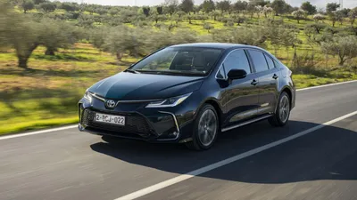 Фото Toyota Corolla Hatchback 2023 на фоне городского пейзажа