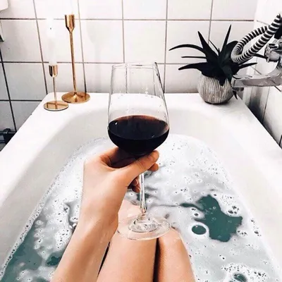 В ванной с бокалом вина фотографии