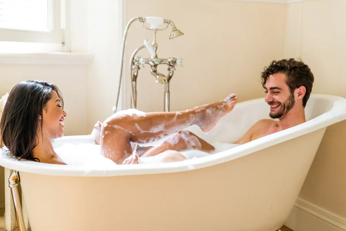 Счастливая молодая пара принимает ванну вместе